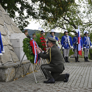 Generál Zmeko kľačí pred pamätníkom 